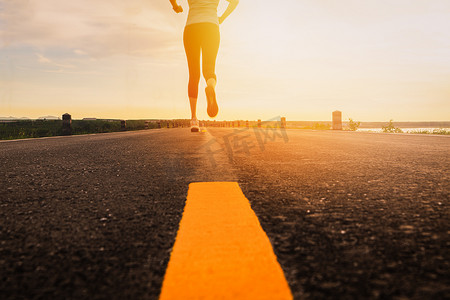 120车在路上摄影照片_运动员在马拉松和健身的日落训练中在公路上奔跑。