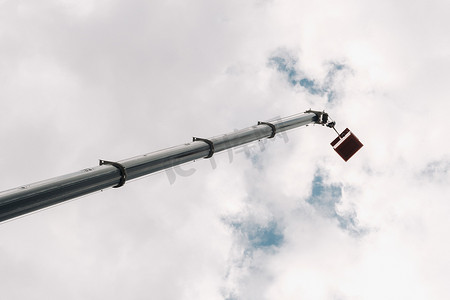 起重机维修摄影照片_在汽车起重机的天空摇篮中高高举起。