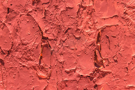 旧墙上的旧片状油漆剥落，表面有裂缝和刮痕