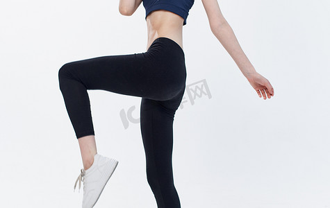 活动浅色背景摄影照片_穿着黑色紧身裤的女人裁剪视图复制空间浅色背景运动健身