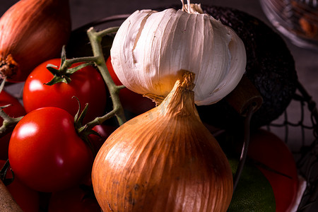 蔬菜海报装饰摄影照片_用洋葱大蒜西红柿装饰厨房的旧篮子的海报