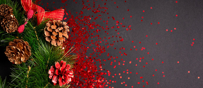 黑色背景上带有红色闪光的圣诞花环，平躺着复制空间