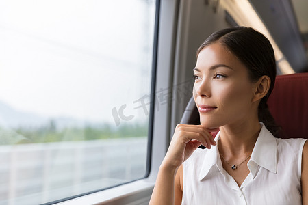 亚洲女旅行者从火车窗外思考户外景色。