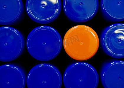 盒子里的蓝色盖子之间有一个橙色喷漆塑料盖，作为一种与众不同、独特的概念，但同时也是团队的一部分。