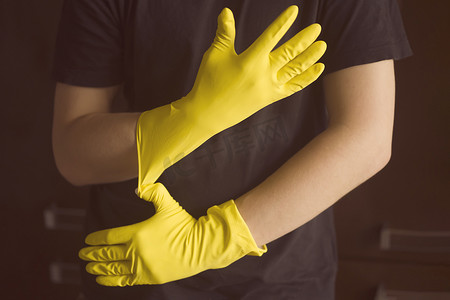 黄色房屋摄影照片_一个戴黄色橡胶手套的女人做家务