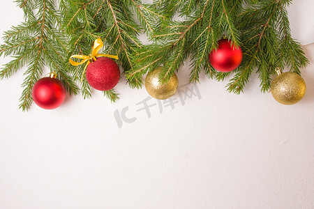 金色和红色的圣诞球和从上方的杉枝在白色背景的顶视图复制空间，由新鲜的天然杉枝制成的框架