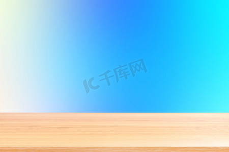 蓝色渐变背景摄影照片_渐变蓝色软背景上的空木桌地板，木桌板空前彩色渐变，浅蓝色渐变上的木板空白，用于展示产品或横幅广告
