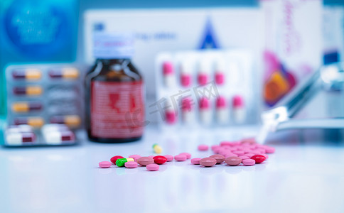 抗菌药物摄影照片_模糊药物托盘上一堆彩色片剂和胶囊丸