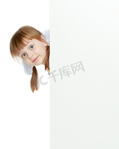 白色横幅摄影照片_一个女孩在白色横幅上展示广告。