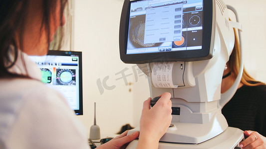 眼科诊所的眼科医生通过现代计算机系统对患者的视力进行诊断 — 高科技医疗保健