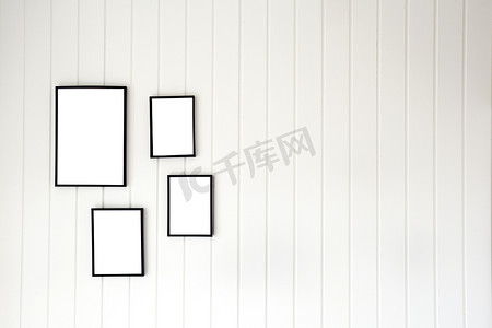 白色木托盘墙，配有空现代风格海报框架，用于复制空间、时尚的帆布装饰室内设计