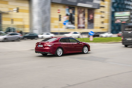 乌克兰，基辅 — 2021年4月26日：红色丰田凯美瑞汽车在街上行驶。