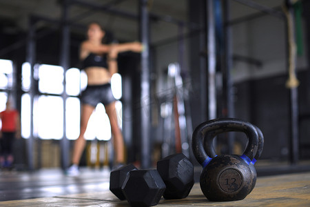 年轻的运动型女人在健身房伸展。
