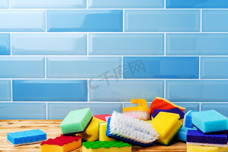 蓝色瓷砖墙上的一堆家用清洁海绵
