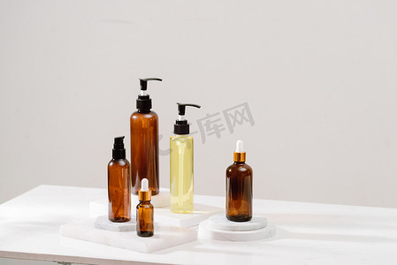 灰色混凝土桌上的棕色玻璃瓶中的水疗化妆​​品。