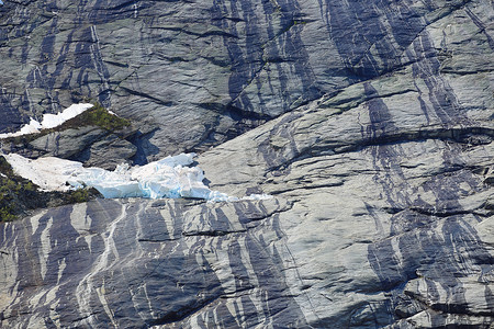积雪融化摄影照片_岩石上的积雪融化
