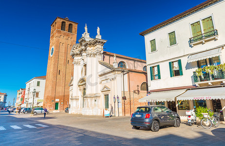 基奥贾 - 2016年9月，意大利威尼托：基奥贾街景、圣安德烈教堂 (Chiesa di SantAndrea)、住宅、商店、汽车和摩托车停在附近