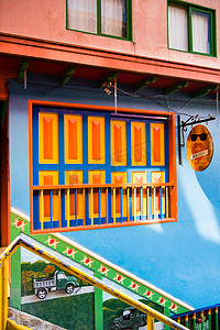 热闹场景摄影照片_哥伦比亚瓜塔佩市中心，拥有橙色和蓝色图案的建筑。