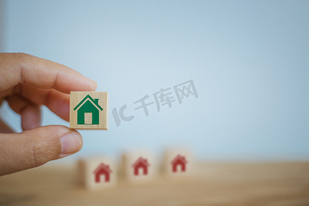 住房贷款、出租房屋、金融概念：手工选择的木立方体块与家庭图标不同。