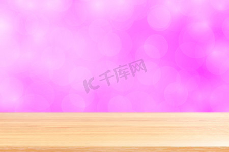 渐变粉红背景摄影照片_模糊的散景软粉色渐变背景上的空木桌地板，粉红色散景彩色浅色上空的木板，彩色散景灯渐变软用于横幅广告产品