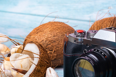 蓝色木质背景中的相机、椰子和贝壳 海洋主题