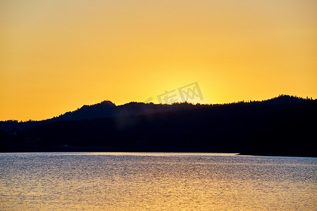水面上的日落日出景观与山的轮廓