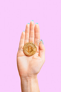 女性手掌上的一枚硬币比特币。