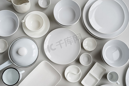 厨房白色摄影照片_灰色背景中成堆的白色陶瓷餐具和餐具顶视图