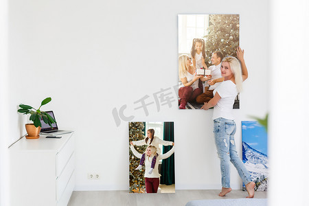 在室内背景上拿着照片画布的女人
