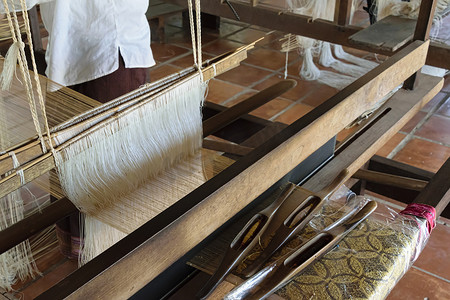 在传统织布机上用丝绸手工编织古代图案