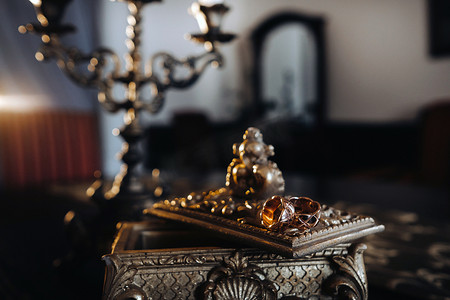 金色结婚戒指放在一个古董首饰盒上。