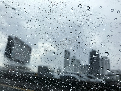 城市雨天摄影照片_雨天城市汽车玻璃上的雨滴