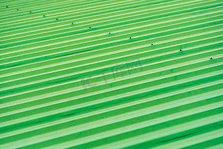屋顶彩绘摄影照片_作为抽象背景的绿色彩绘金属屋顶