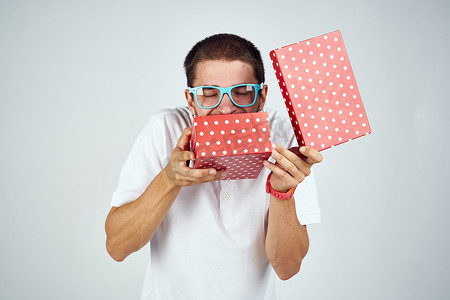 男士生日背景摄影照片_戴眼镜的男士礼盒节日趣味浅色背景
