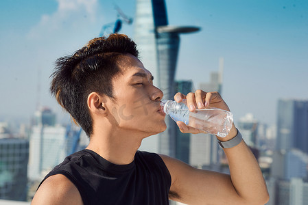 一个男人从外面的瓶子里喝水的特写