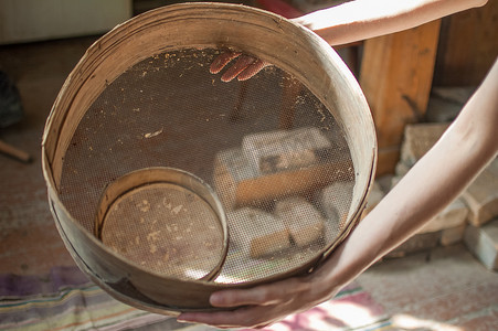 乡村工作摄影照片_旧筛子，过去用于女性手中筛面粉的面包店工具