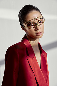一位身穿红色夹克、脸上戴着珠宝的时尚女性肖像 铁质眼镜 新技术