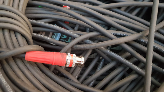 一卷带红色插头的黑色电缆特写。
