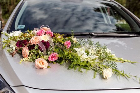 灰色婚车引擎盖上的花卉装饰。