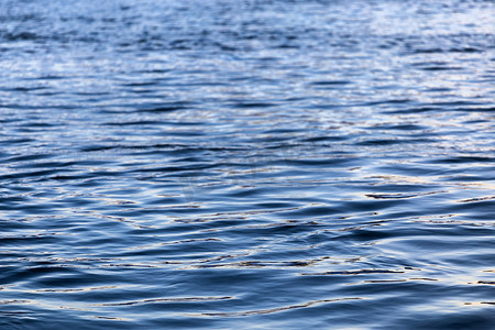 蓝色水面波纹背景摄影照片_具有小平原波纹和选择性焦点的抽象水面特写