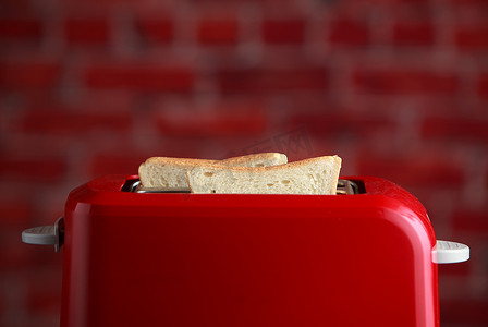 木制背景上烤切片面包的烤面包机。