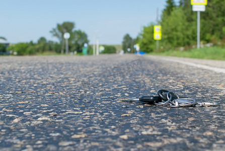 沥青路摄影照片_在道路的沥青路面上丢失了一串钥匙
