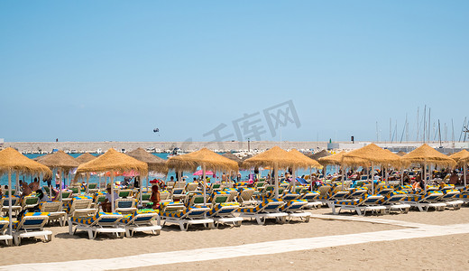 度假者摄影照片_度假者在海滩上享受日光浴