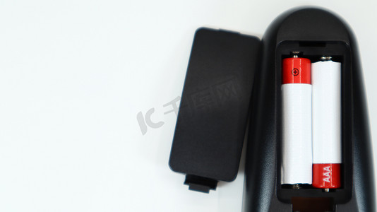 视频黑摄影照片_有在红色和白色的AAA碱性电池的黑电视遥控在白色背景。