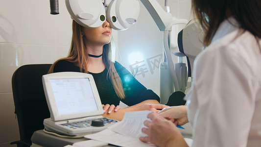 眼科 — 白人女性在眼科医生室检查视力 — 医学高科技