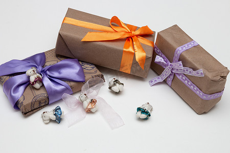 白色背景盒子里的礼物复制顶视图金色丝带，蝴蝶结包裹在棕色纸紫色丝带编织可爱熊装饰