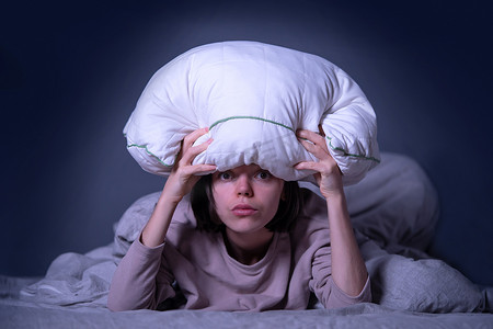 女人盖着毯子，担心失眠、压力大。