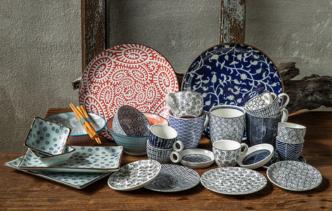陶瓷工艺摄影照片_不同的陶瓷盘子、碗和杯子在木桌上。