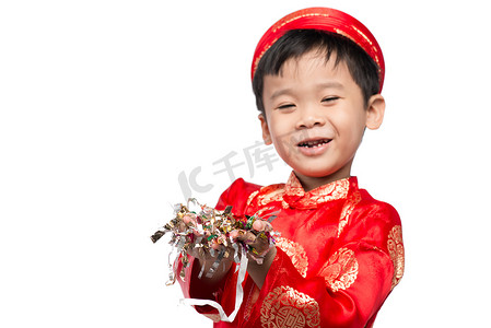 穿着红色 Ao Dai 的快乐越南男孩用五彩纸屑庆祝新年。