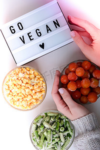 灯箱上写着“去素食”三碗冷冻蔬菜食品，包括黄玉米、青豆、红西红柿。
